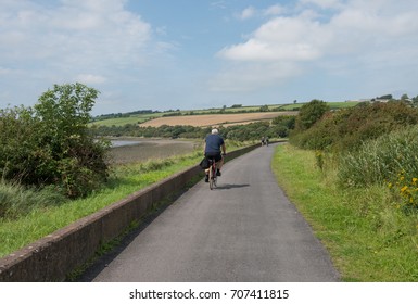 Grey Haired Male Cycling Along The Tarka Trail, Part Of The South West Coast Path, On The Estuary Between Braunton And Barnstaple In North Devon, England, UK