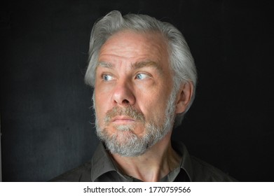 Grey haired man with a beard scared