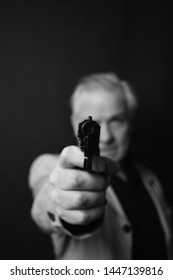 Grey haired man gangster with revolver