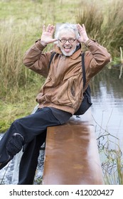 Grey Haired Older Man Making A Funny Face In A Nature Background
