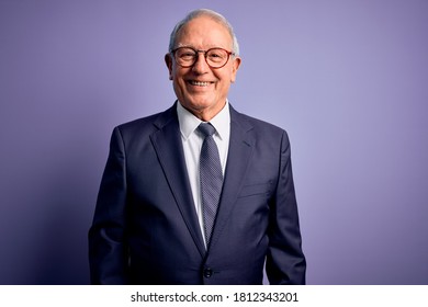 Grey Haired Senior Business Man Wearing Glasses And Elegant Suit And Tie Over Purple Background With A Happy And Cool Smile On Face. Lucky Person.