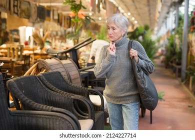 Grey Haired Woman Choosing Chair In Furniture Shop.