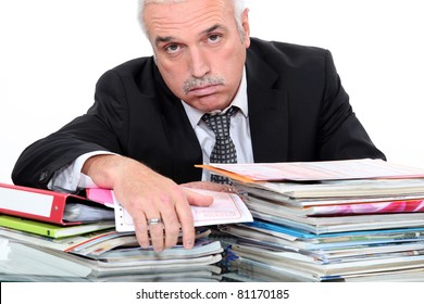 Grey Hairy Man Looking Fed Up In Front Of Paper Work