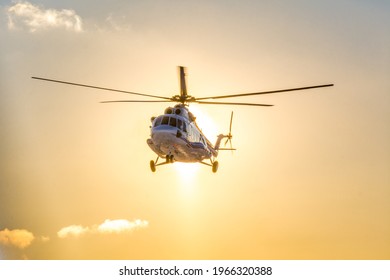 Grey Helicopter Landing Against Sunset