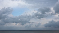 Grey High Layered Grey Epic Clouds On Blue Sky Above Thin Sea Water Line. Heaven Cloudscape Air View