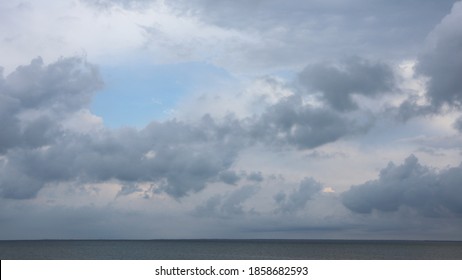 Grey High Layered Grey Epic Clouds On Blue Sky Above Thin Sea Water Line. Heaven Cloudscape Air View