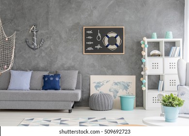 Grey Home Interior With Nautical Wall Decor, Sofa, Carpet And White Storage Unit