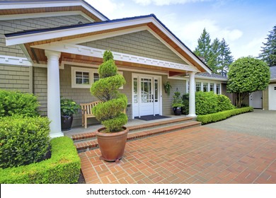 Grey House With White Trim And Brick Walkway. View Of Entrance Column Porch.