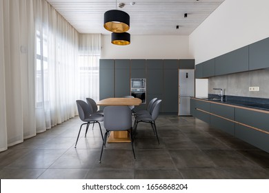 Grey Kitchen Furniture. Built-in Household Techie. Black With A Gold Chandelier Over The Table. Panoramic Windows. Light Interior. Ceiling Sweats. Modern Furniture For The Dining Room.