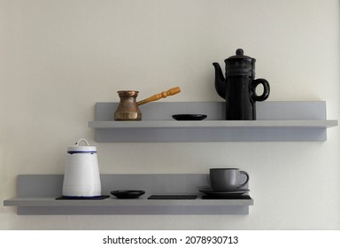 Grey kitchen shelves and set of teapot,cup,cezve,jar on it.Empty wall