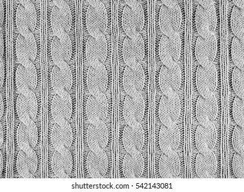 Grey knitted textured background with a pattern closeup