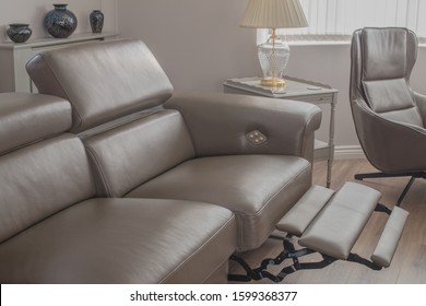 Grey Leather Sofa Recliner In Open Position In Living Room, With Side Table And Single Chair.