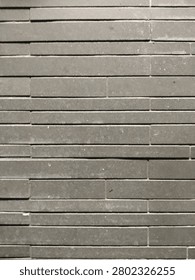 Grey linear stone wall texture. Seamless pattern of contemporary dark gray concrete cladding tiles
