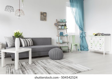 Grey living room with a mint curtains and white walls