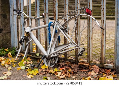 Grey Locked Bike With Stolen Wheels