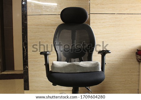 Grey memory foam coccyx cushion in black office chair