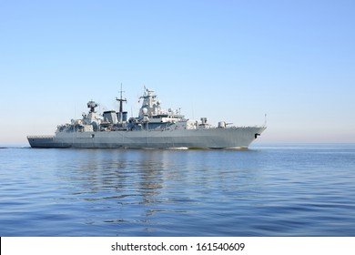 Grey modern warship sailing in still water 