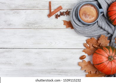 Grey Mug Of Coffee Wrapped In Plaid Or Scarf, Spices, Dry Oak Leaves, Acorns, Orange Pumpkins On White Wooden Table. Autumn Drink Concept. Fall, Pumpkin Spicy Latte, Thanksgiving, Top, Copy Space