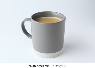 Grey mug of freshly brewed hot coffee on white background