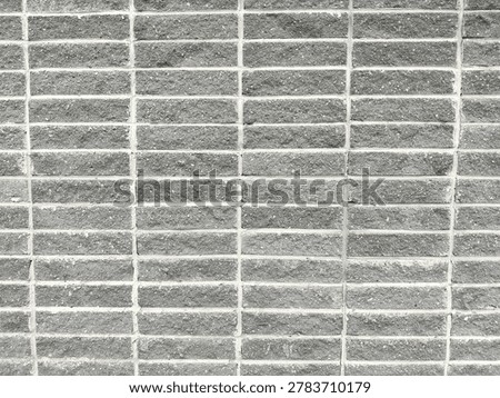 grey narrow oblong ceramic tile with a texture imitating brick, with a raised surface