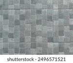 Grey paving slabs with equal sides. Sidewalk decoration with rough structure. Geometric pattern with different tints of gray squares.