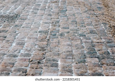 Grey Paving Stones Close-up. Texture Of An Old Dark Stone With Wet Snow, Slush And Mud. Road Surface With Snow. Vintage, Grunge.