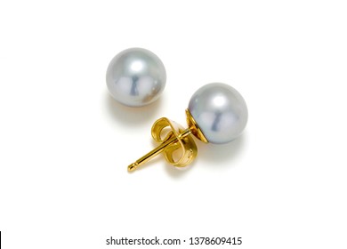 Grey pearl stud earrings in gold on a white background. 