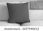 Grey pillow over white sofa and blanket
