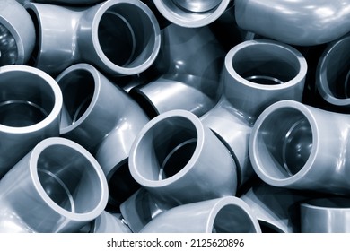 Grey pvc plumbing pipes corners background closeup