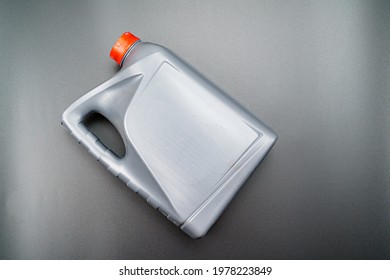 Grey With A Red Lid Canister With Machine Oil On A Black Background. Motor Oils To Reduce Friction Between Moving Engine Parts. Car Service And Shop