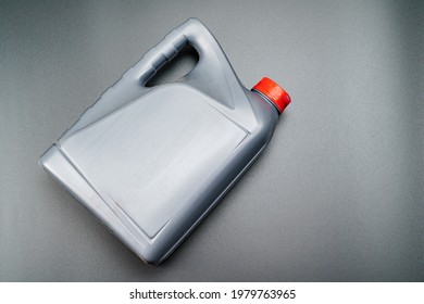 Grey With A Red Lid Canister With Machine Oil On A Black Background. Motor Oils To Reduce Friction Between Moving Engine Parts. Car Service And Shop