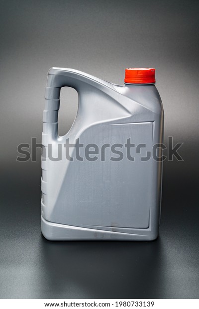 grey with a red lid canister with\
machine oil on a black background. Motor oils to reduce friction\
between moving engine parts. Car service and\
shop