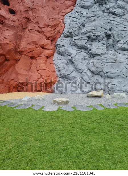 grey and red wall decoration as Mars and moon\
surface with green grass