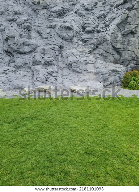 grey and red wall decoration as Mars and moon\
surface with green grass