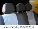 Grey seat back with Grey seat back. Grey seats with white stitching in old passenger van. Modern van interior. Vans seats row close up. 