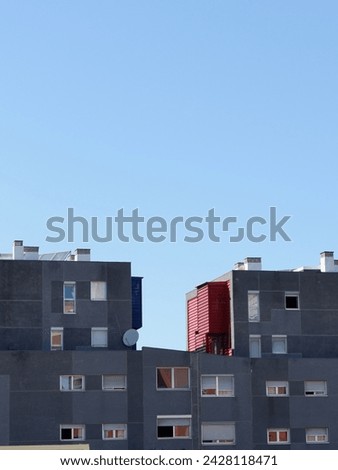 Grey simplistic lines of modern buildings against the clear sky. Modern architecture. Minimalistic design.