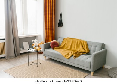 Grey Sofa In The Living Room In A Scandinavian Minimalist Natural Style With Yellow And Red Color Accents. Autumn Home Decor