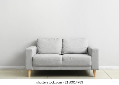 Grey sofa near light wall - Shutterstock ID 2150014983