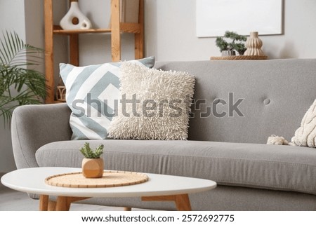 Grey sofa with soft cushions in living room