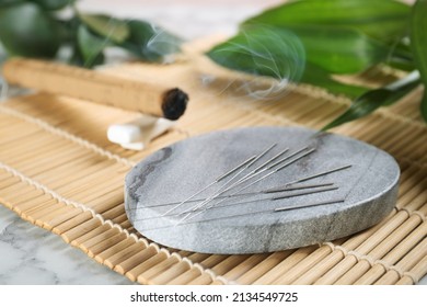 Grey Stone Coaster With Acupuncture Needles On Bamboo Mat