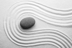 Серый камень на песке с рисунком, вид сверху. Дзен, медитация, гармония