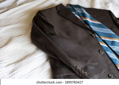 Grey Suit With Blue Tie Laid Out On A Bed