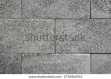 Grey textured rectangular stone wall background. Coarse granite texture