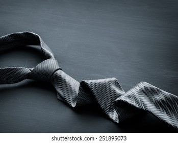 Grey tie on dark background