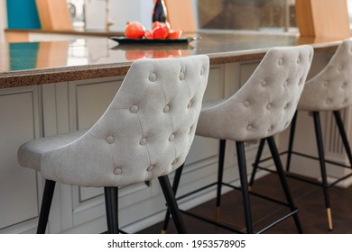 grey velour chair with high black legs in the interior