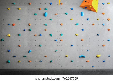 Grey Wall With Climbing Holds In Gym