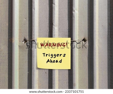 Grey  wall with stick note WARNING! triggers ahead - concept of knowing your triggers, to aware or identify emotion triggers when encountering something difficult