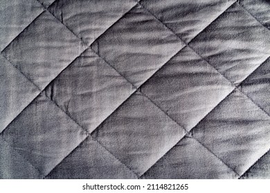 Grey weighted blanket texture detail, heavy padded relaxing bed sheet cover filled with glass beads