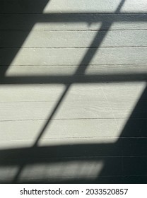 grey wood flooring with window pane shadow