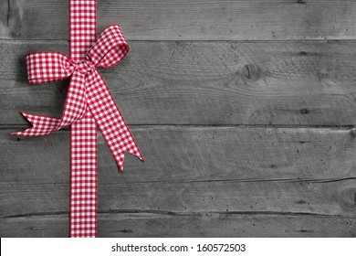 Grey wooden background with red and white checkered bow as border - Powered by Shutterstock